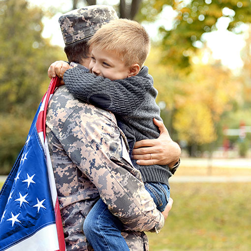 Service member hugging child