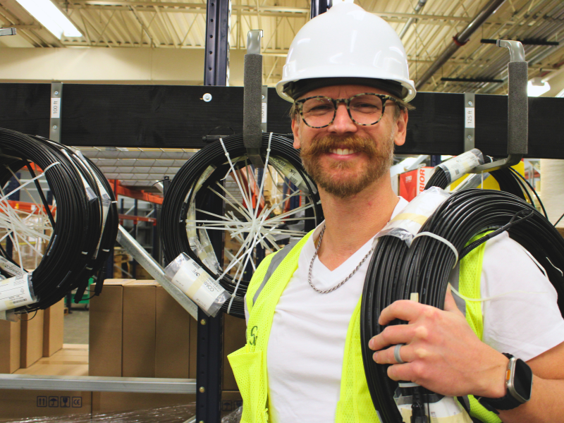 An ALLO employee holding a fiber cable.