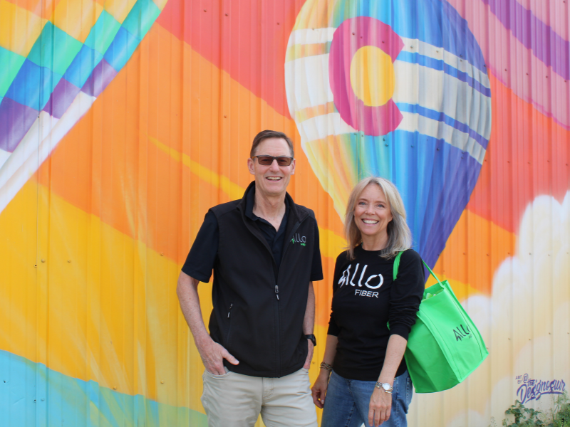 ALLO Fiber employees in front of an Erie mural.