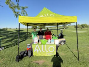 ALLO employees under a tent at a golf course